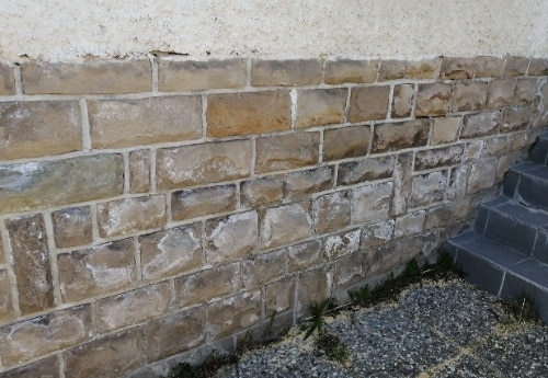 apparition de salpêtre sur un mur en pierre à cause de remonétes capillaires dans le mur